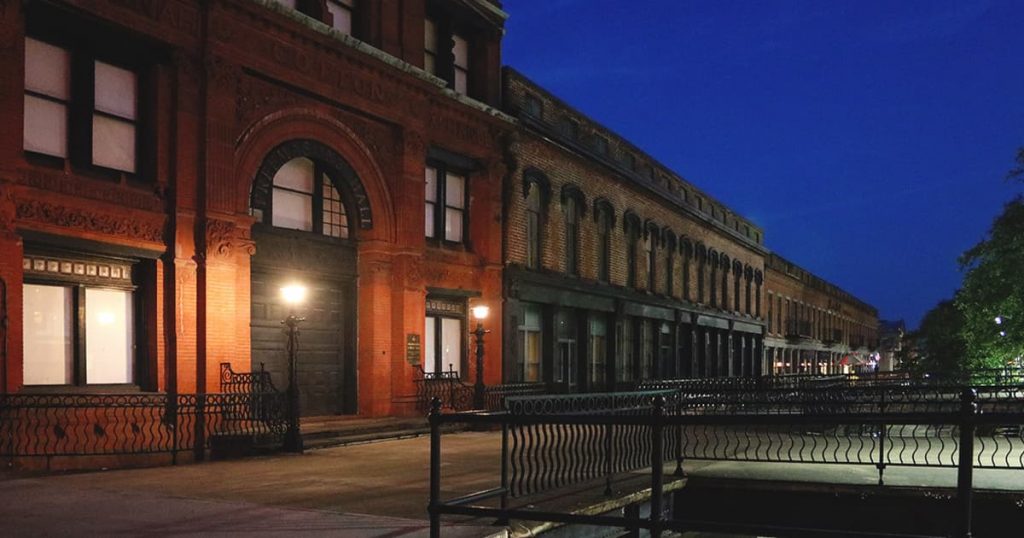 Row of brick buildings at night shrouded in mist