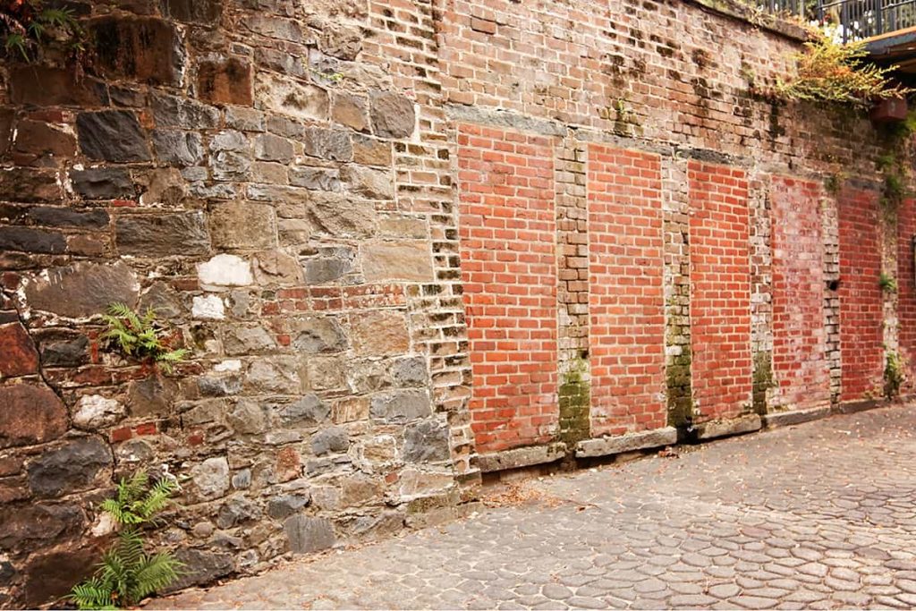 Old rock wall with tunnels that have been sealed closed with bricks