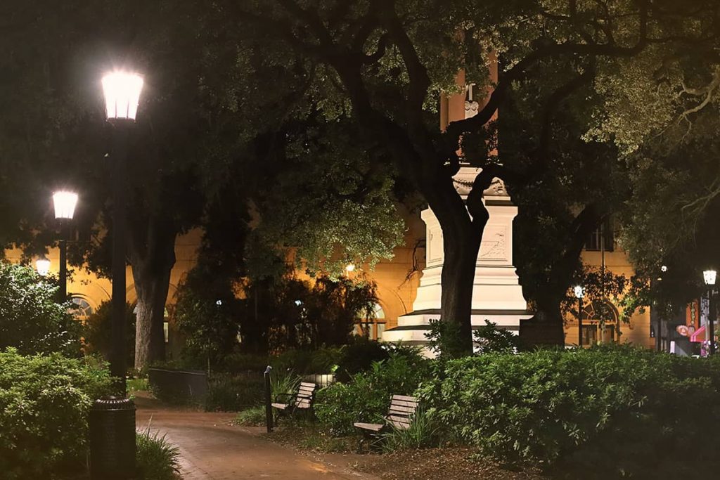 Haunted Wright Square at night with gas lanterns illuminating red brick sidewalks