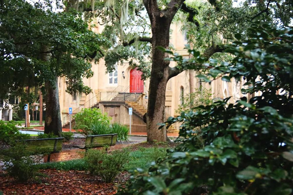 Rain-soaked Calhoun Square in Savannah with Wesley Monumental Church seen in the background.