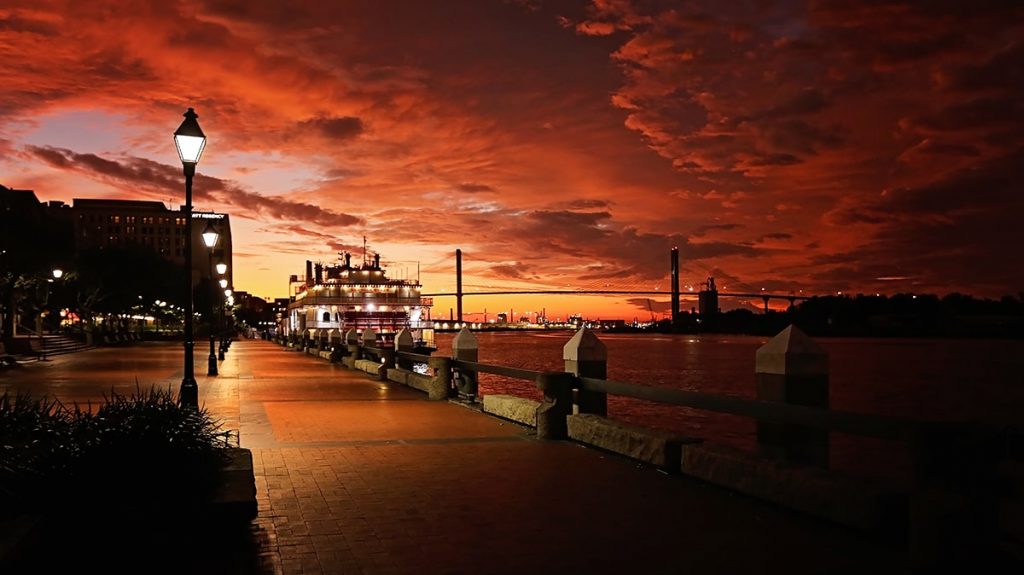 River Street Savannah GA with a fiery red and orange stormy sky in the background