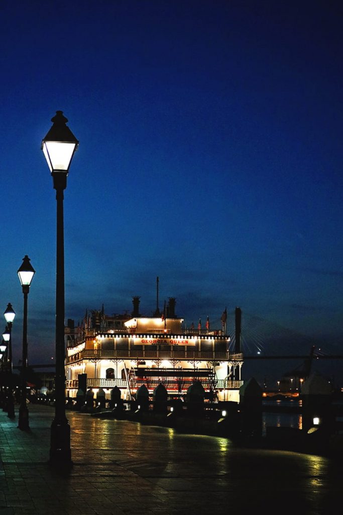 Georgia Queen steamboat docked on River Street with deep blue night sky in background