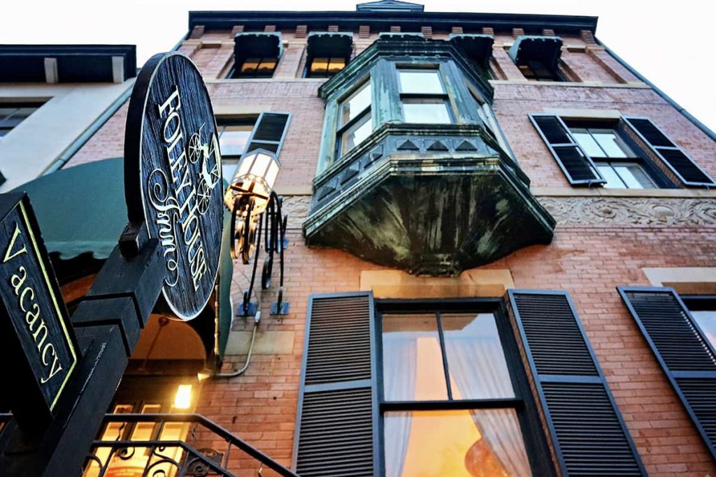 Peering up at the brick facade, black shutters, and iron bay windows on the front of the Foley House Inn -- one of Savannah's most haunted B&Bs.