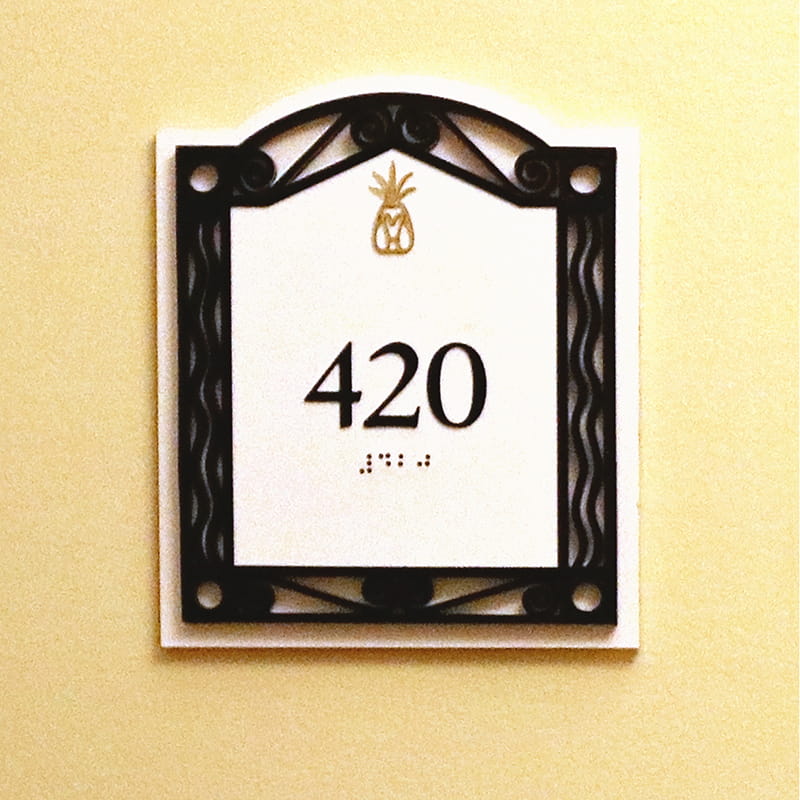 White sign with gold pineapple and black frame with the number 420