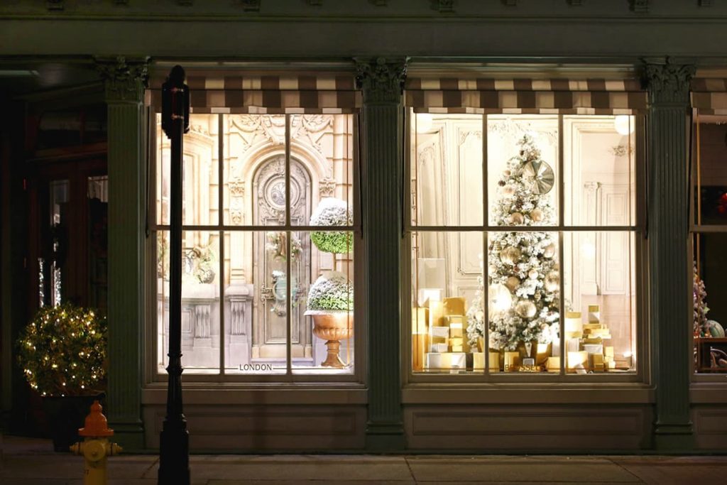 Parisian-themed Christmas window display in a cute shop with green trim around the windows on Broughton Street in Savannah GA