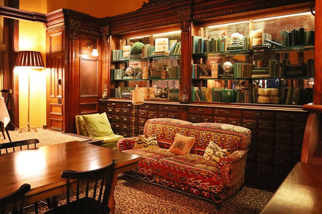 Cozy interior of Gryphon in Savannah with upholstered furniture, lamps, and bookshelves stuffed with books