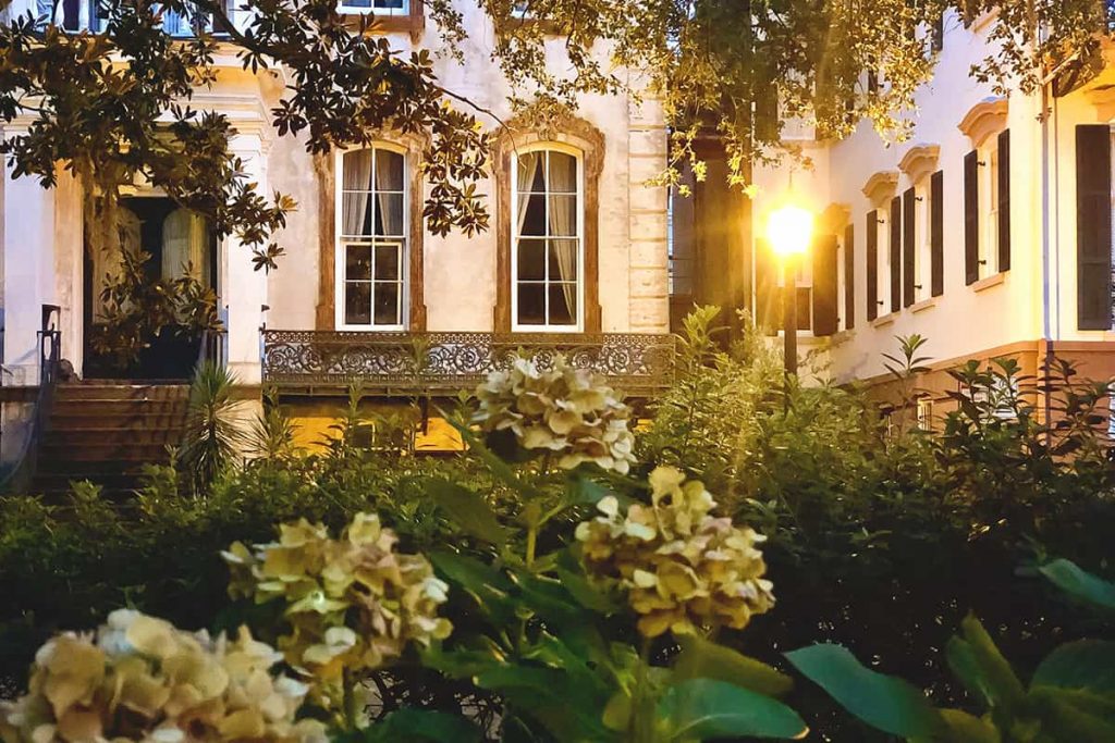 Hydrangeas in the foreground and Alex Raskin Antiques at dusk in the background