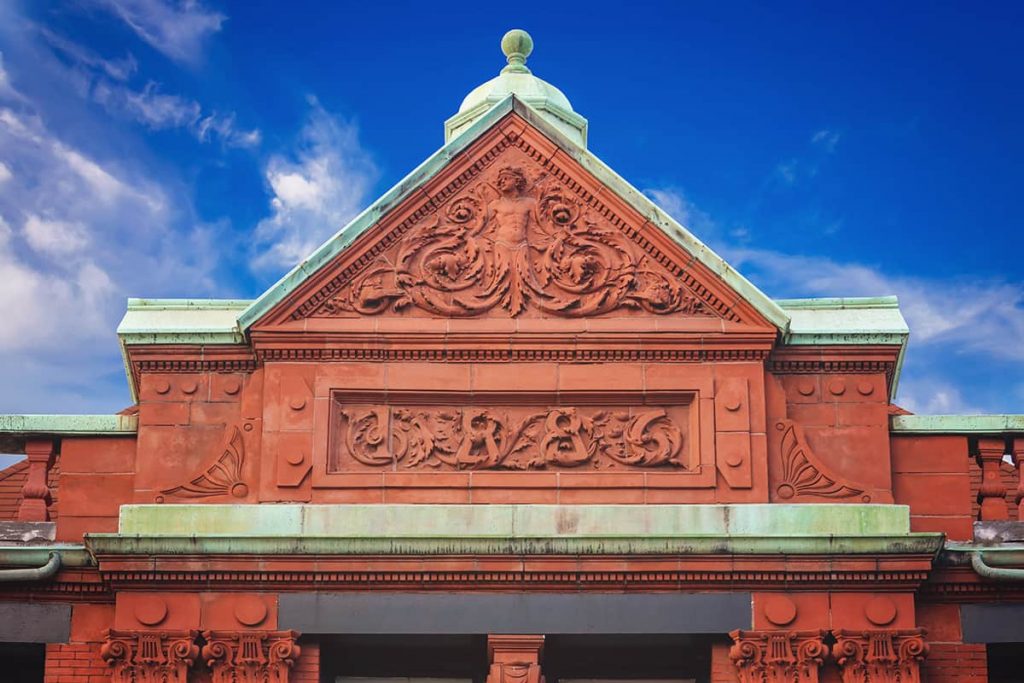 Terra cotta details on the roof of the Old Savannah Cotton Exchange indicate a date of 1886. The copper trim has aged to a soft green patina