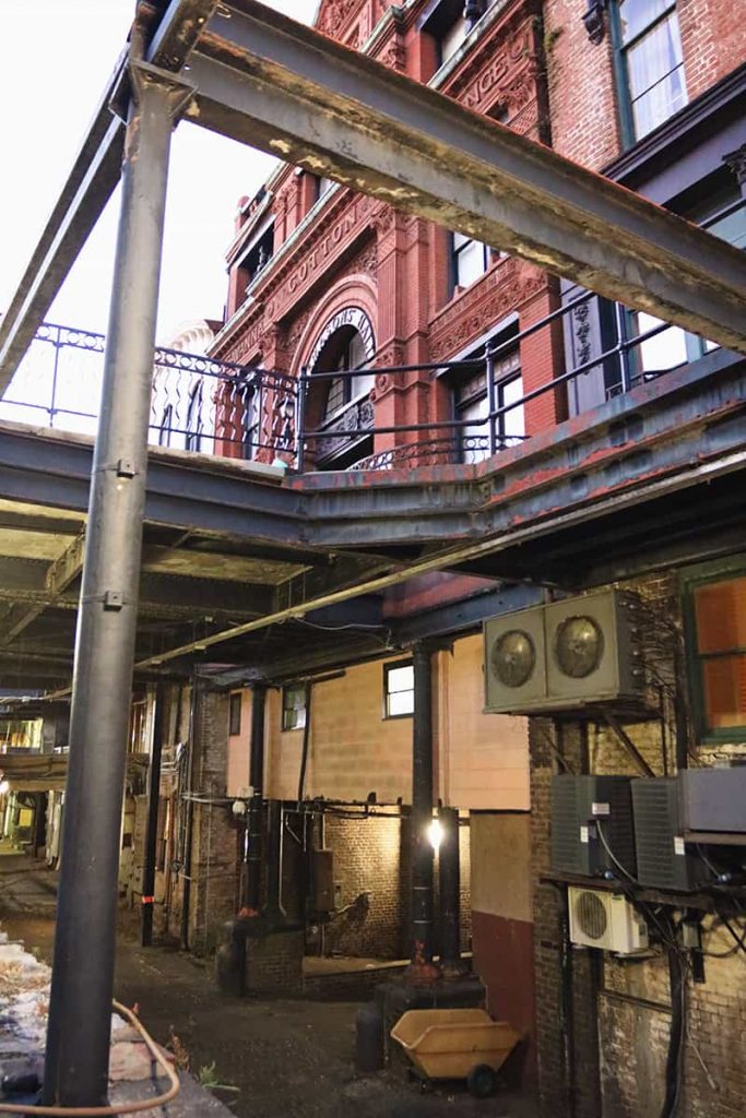 Historic Cotton Exchange building as seen from below, with a utilitarian bottom level and an elaborately detailed terra cotta upper level