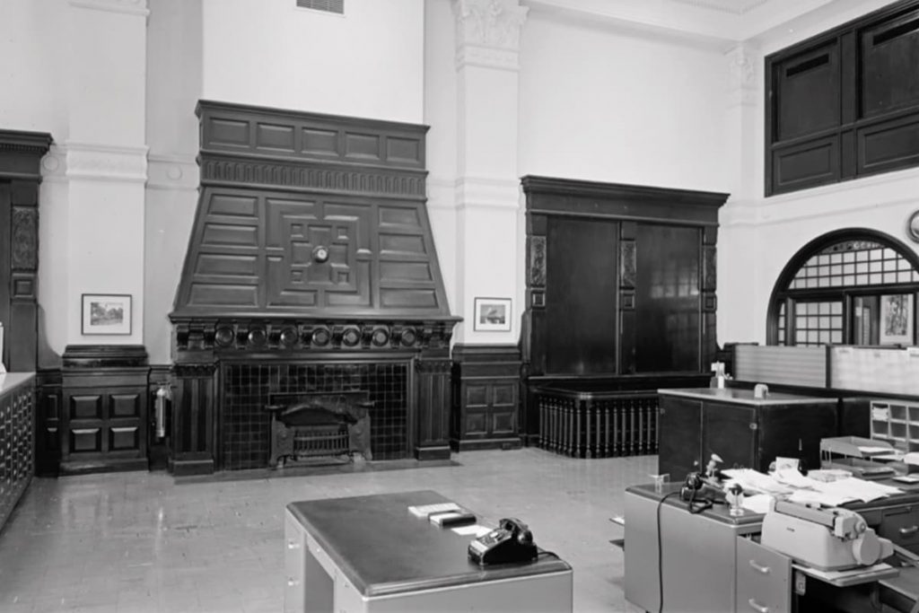 Room inside the Old Savannah Cotton Exchange building with an oversized fireplace and desks set up for use as an office space