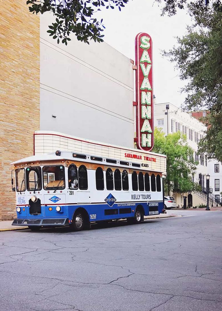Blue and white Kelly Tours trolley parked in front of the Savannah Theatre marquis sign