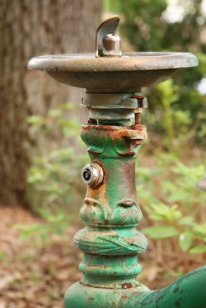 An old and rusted green water fountain in Savannah's Forsyth Park