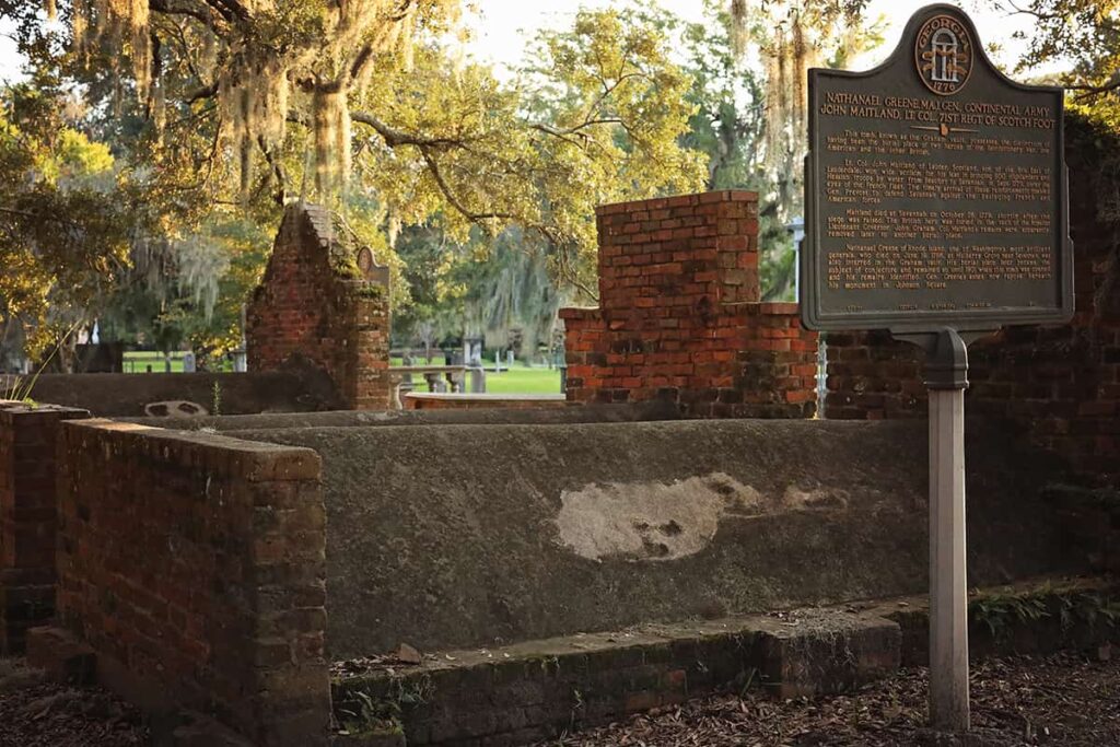 Two vaults in Colonial Park Cemetery. The one in the foreground has a white shape on it that looks like a ghost with dark spots for the eyes and mouth