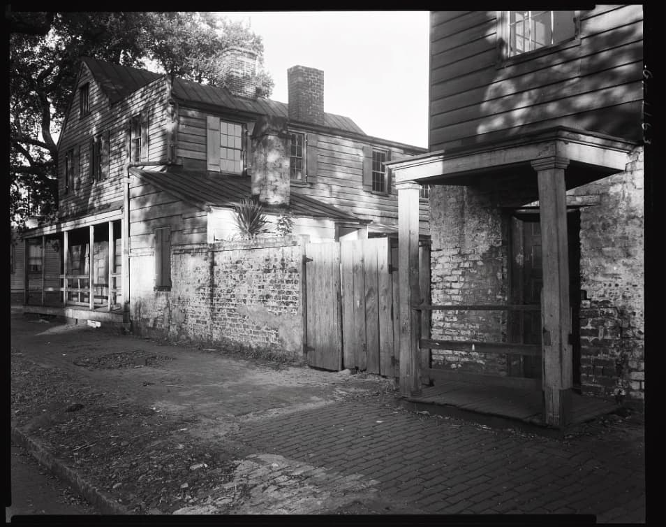 B&W historic photo of The Pirates' House building in Savannah with a structure made from a mixture of whitewashed bricks and wood