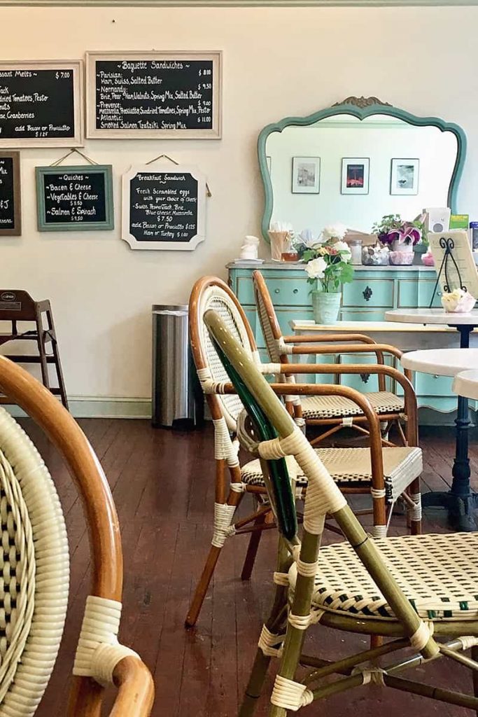 Wicker chairs and a beautiful mint green colored dresser with teas on the top at Cafe M in Savannah