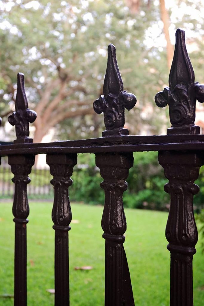 Wrought iron fence with one spike missing along the top row of spikes