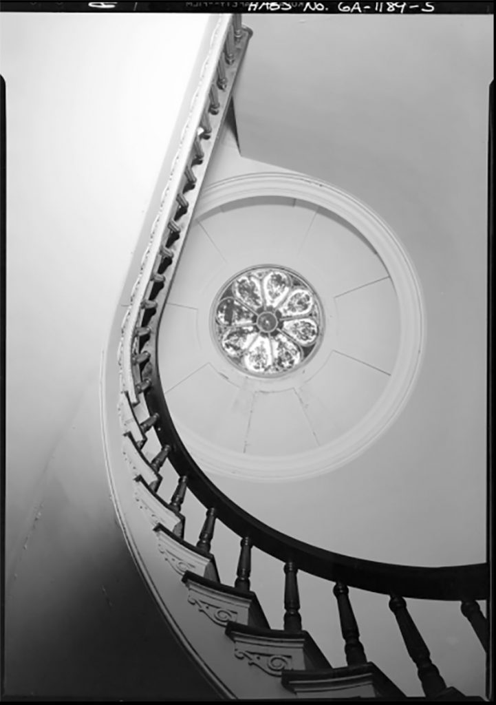Historic B&W image of the curved stairwell of the Mercer House with a circular skylight illuminating the area
