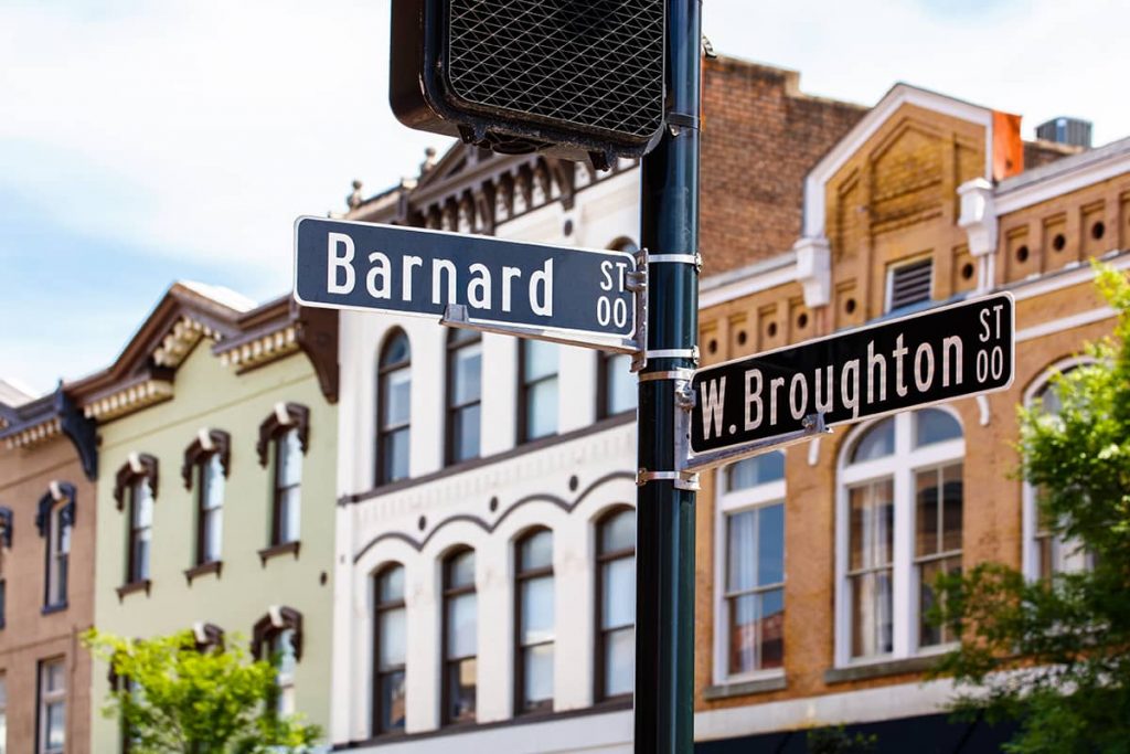 Broughton Street sign with facades for multiple historic storefronts in the background