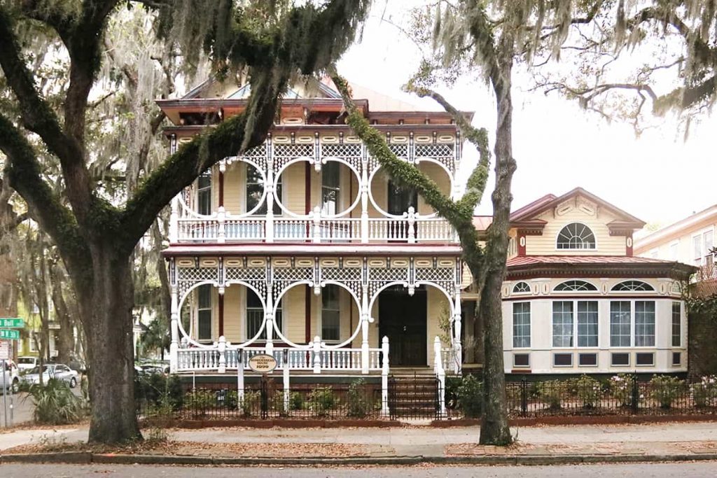 Savannah Georgia's Gingerbread House painted yellow with red trim and a white porch