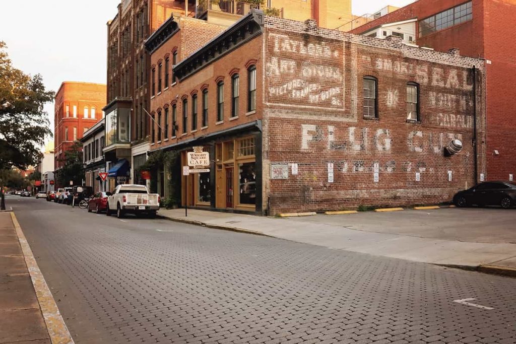 Historic brick building in Savannah with a hand-painted sign for Taylor's Art Store