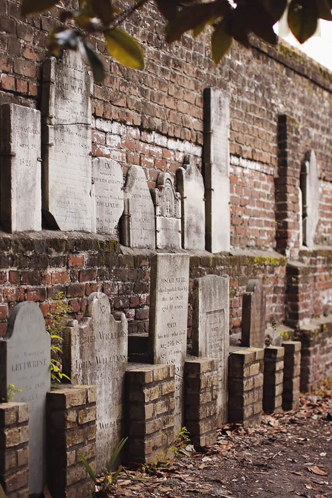 A brick wall with old headstones secured to it in Colonial Park Cemetery