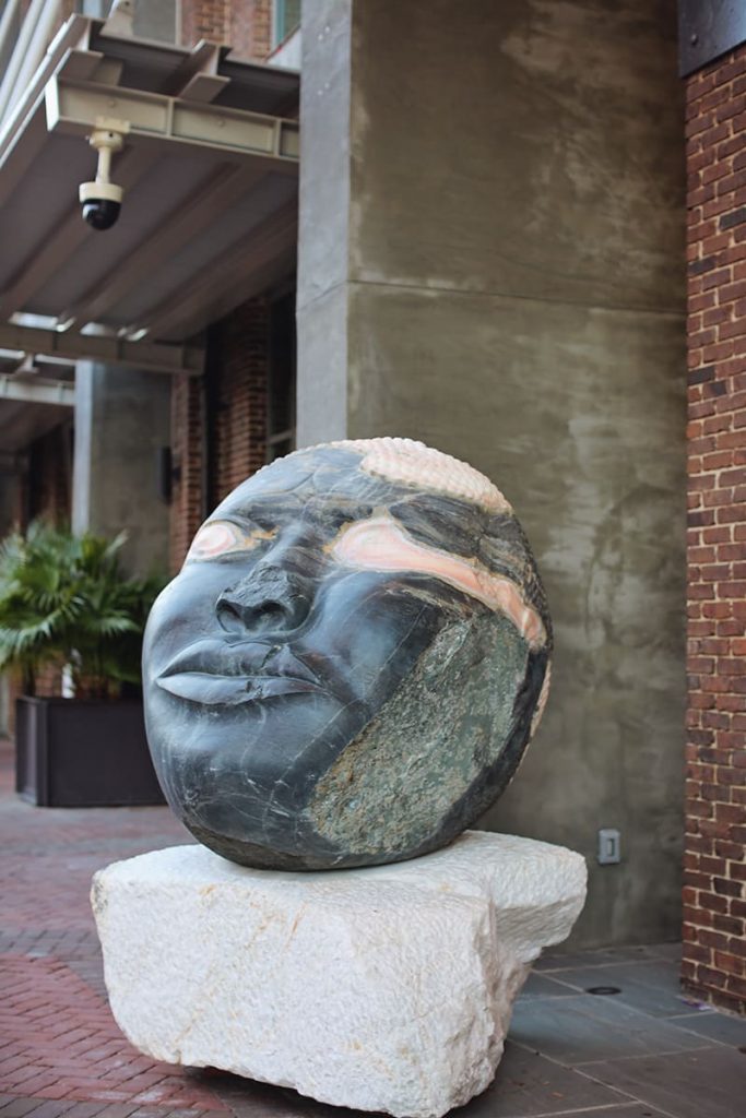 Large face sculpture carved out of a black stone