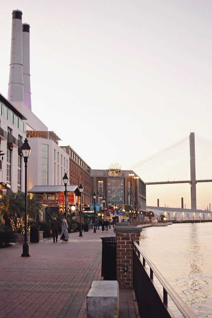 The JW Marriott Plant Riverside building with two smokestacks and a bridge in the distance