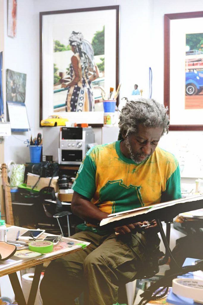 Savannah artist William Kwamena-Pohin a colorful t-shirt at work in his studio in City Market