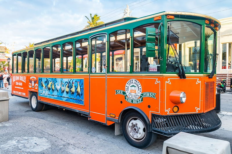 Orange and green trolley with an Old Town Trolley logo near the door