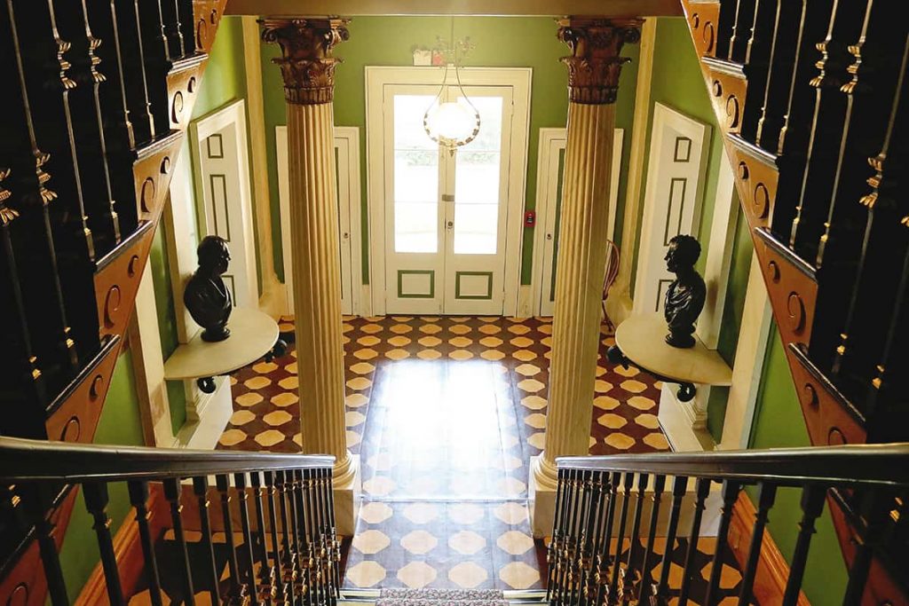 An elegant entry at the Owens-Thomas House with busts of men on tables at each side of the door