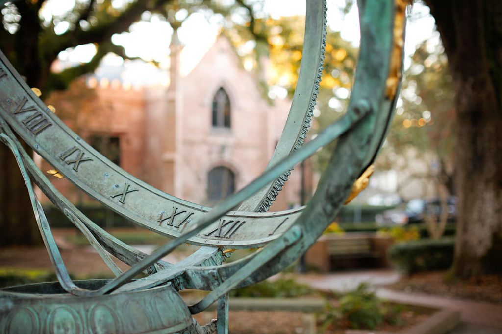 Point of View: Peering through an Armillary Sphere in Troup Square at a gothic-style church lit by sunlight in the background