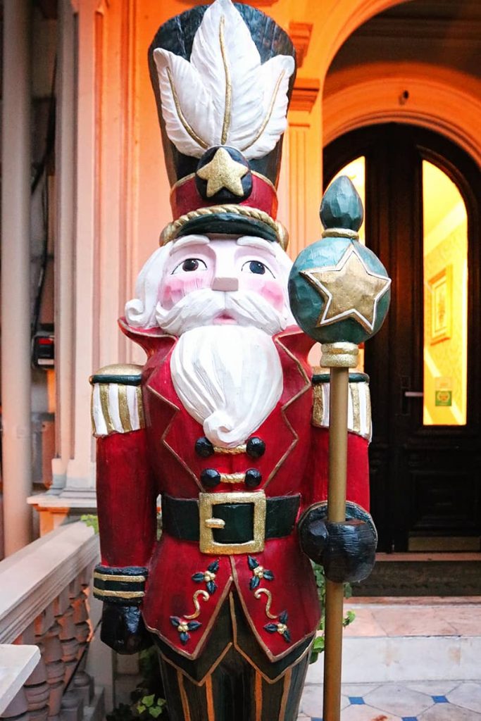 A life-sized nutcracker wearing a red and green suit stands in front of the Hamilton-Turner Inn -- one of the B&Bs in Savannah that decorate for Christmas.