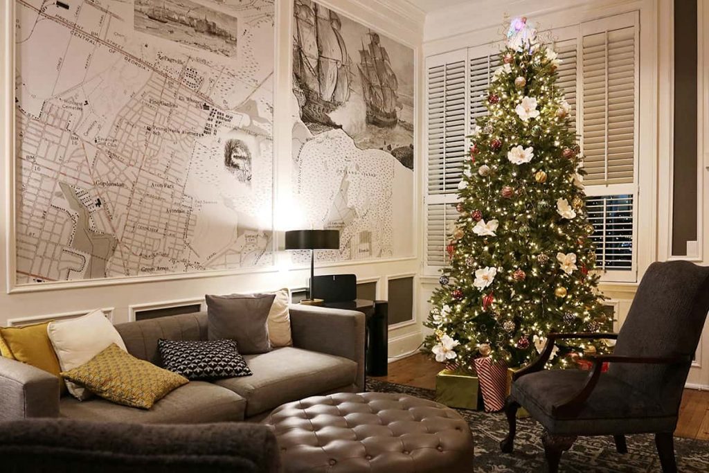 The check-in area of River Street Inn with a traditional Christmas tree decorated with large Magnolia blossoms