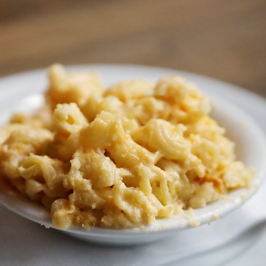 Heaping bowl of creamy mac 'n cheese on a white plate