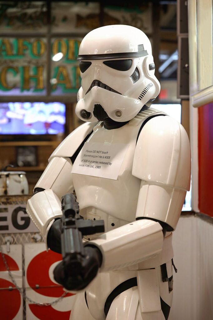 A white stormtrooper holding a black weapon with a sign denoting that its a limited edition #305 out of 500 stormtroopers