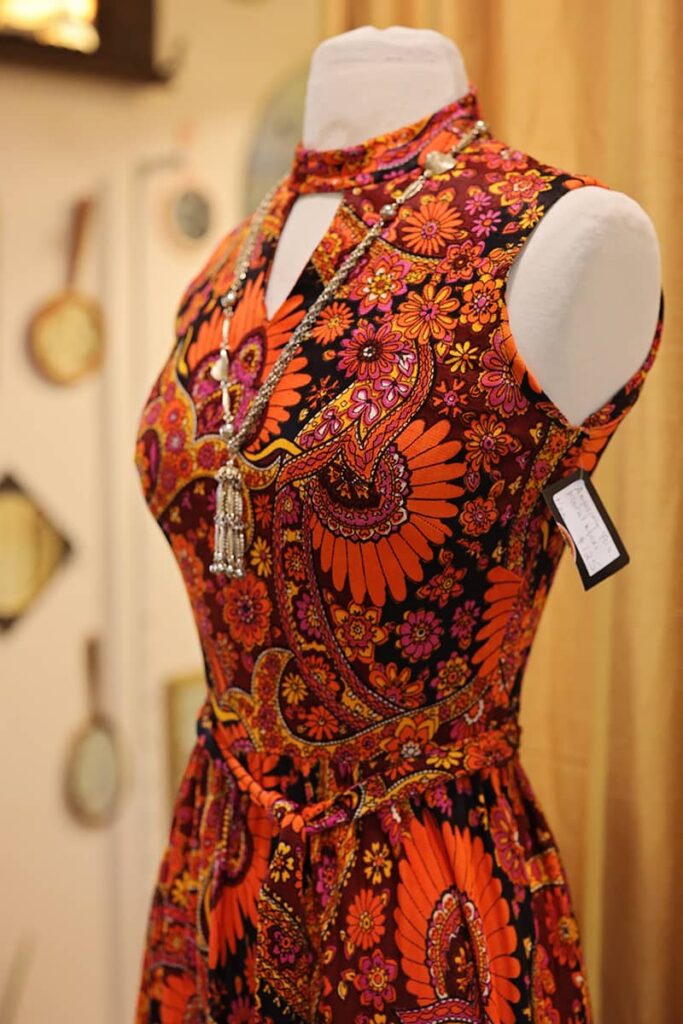 Form-fitting orange and hot-pink paisley dress on a mannequin at Vintage Vortex in the Starland District