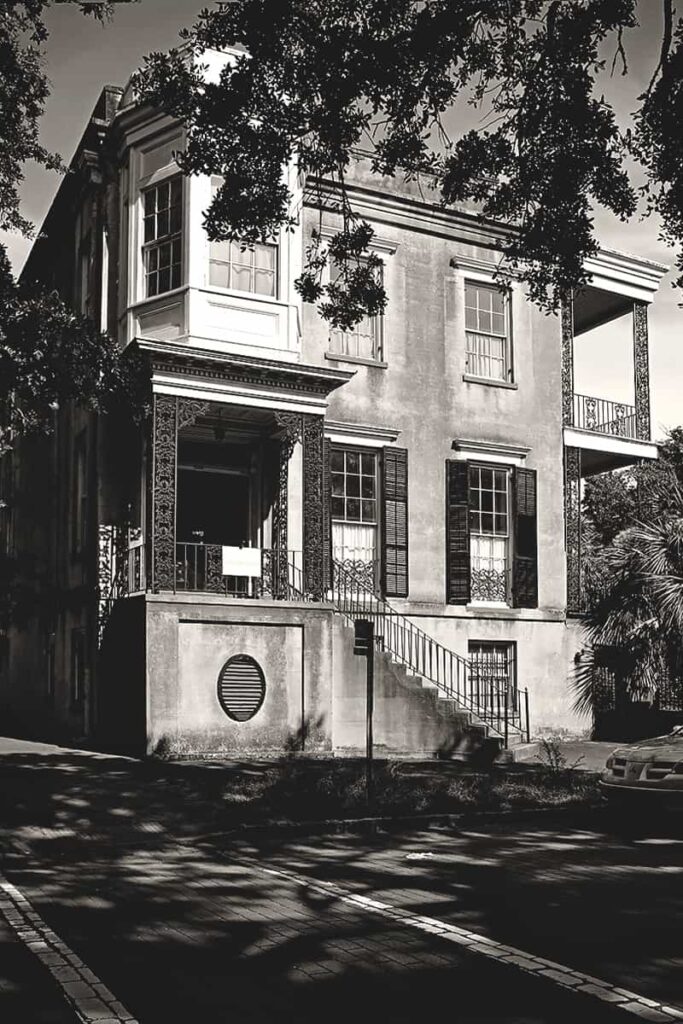 B&W front facade of the three-story home located at 432 Abercorn Street in Savannah before its restoration. It's considered one of the most haunted places in Savannah, and in this photo it appears abandoned and in need of some love