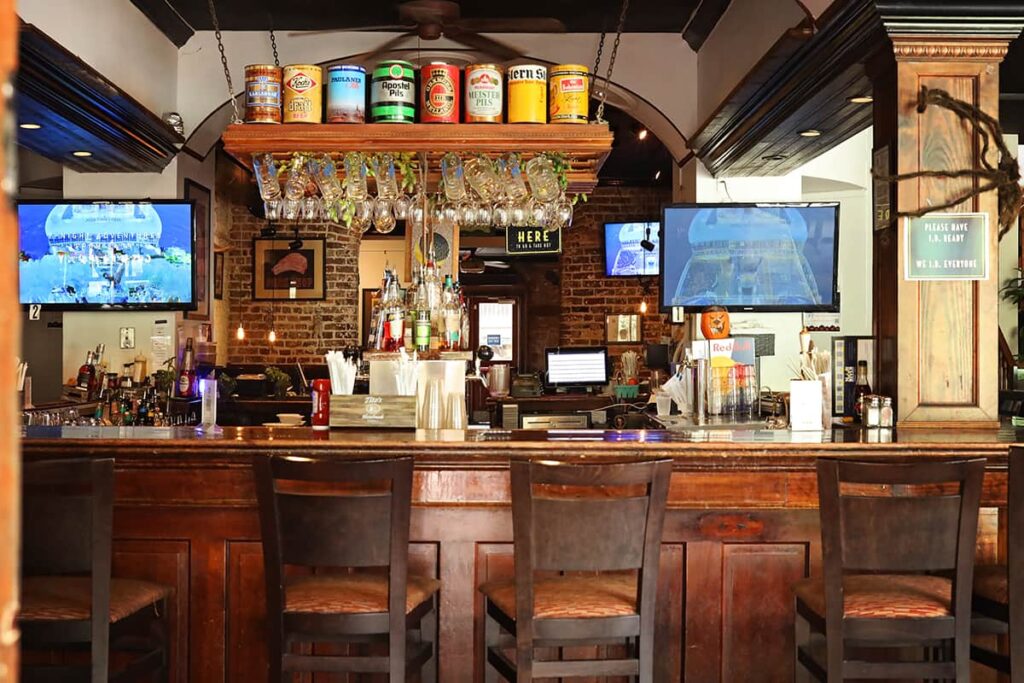 The old wood-trimmed bar inside Moon River Brewing with an exposed brick wall in the background