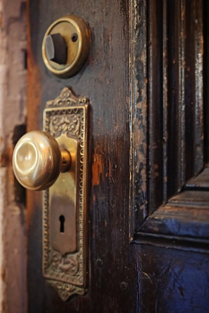 Close-up of a worn brass doorknob on an old wooden door at the Eliza Thompson House in Savannah