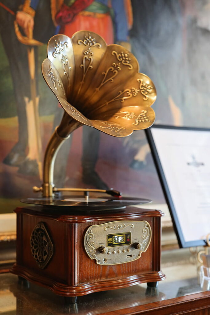 A vintage wooden LugoLake turntable with a copper gramophone sits in the lobby of The Marshall House against a backdrop of colorful art