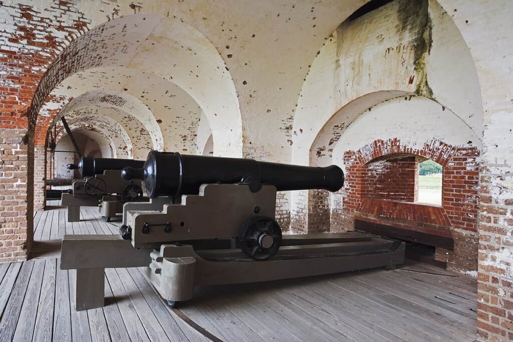 Interior of Fort Pulaski showing arched brick walls and canon-firing mechanisms pointed at small windows