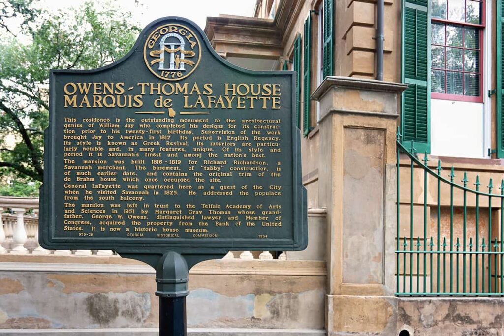 Historic marker for the Owens-Thomas House shows gold text on a green background and tells the story of the Marquis de Lafayette visiting the home