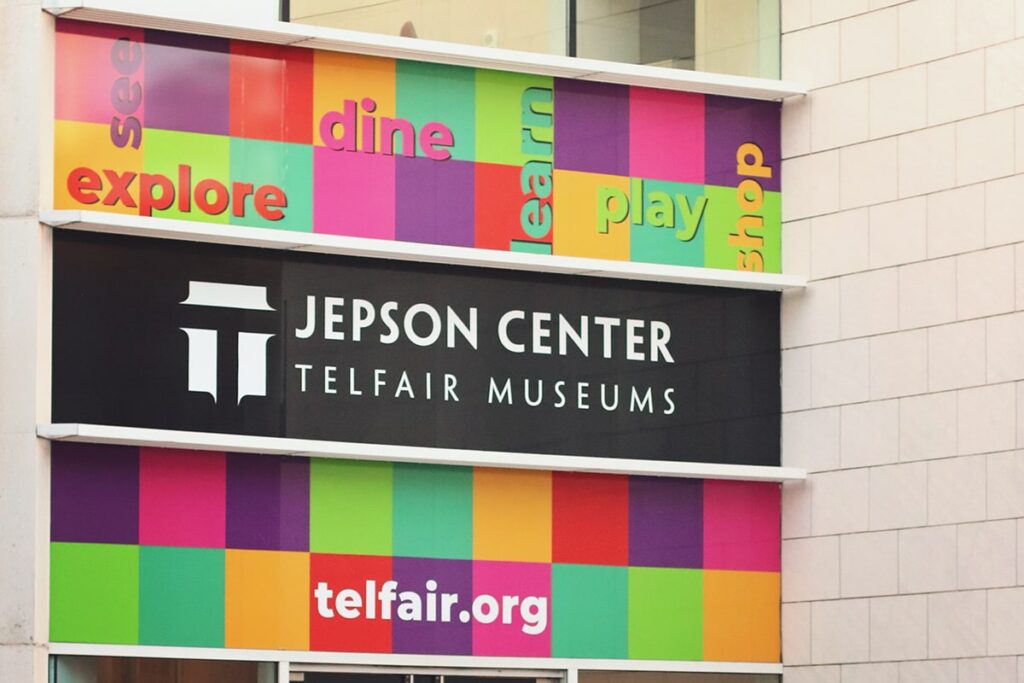 Jepson Center logo in white on a black background and the words "see" "dine" "explore" "learn" "play" and "shop" written in colorful text on a backdrop of colorful squares