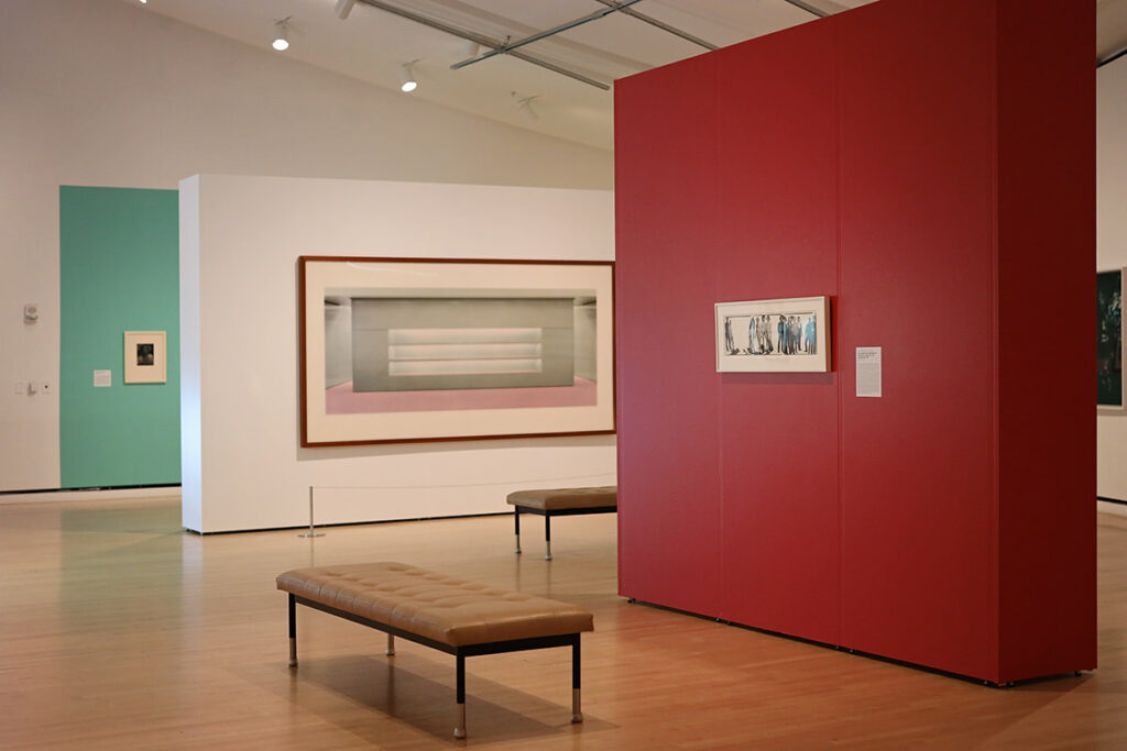 Photography on display inside the Jepson Center on walls painted in different colors to make each piece stand out. One wall is a deep red, one is mint green, and another is pure white