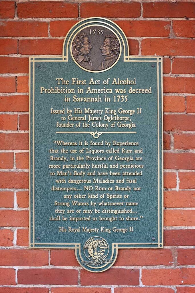 A plaque on the exterior brick wall of one of the museums in Savannah GA shows a declaration stating, "The First Act of Alcohol Prohibition In America was decreed in Savannah in 1735" and is signed by "His Royal Majesty King George II"