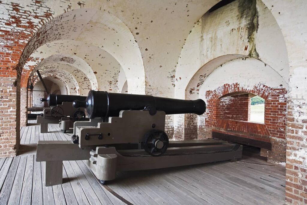 Interior of Fort Pulaski on Tybee Island, Georgia, showing arched brick walls and canon-firing mechanisms pointed at small windows