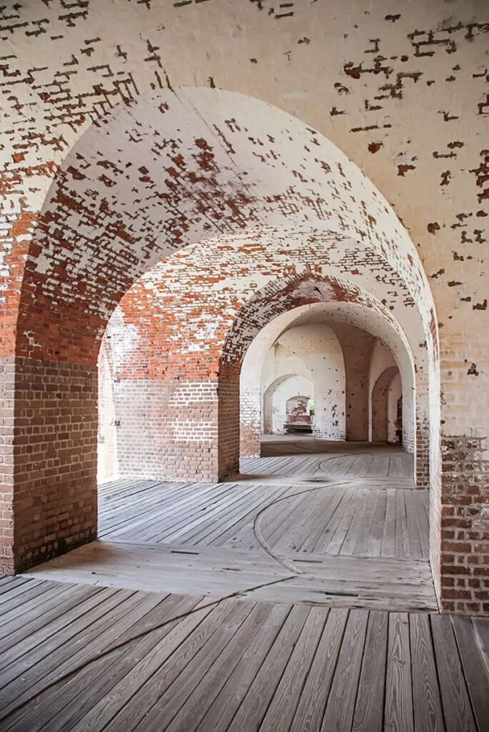 Rows of arched brick doorways covered with fading white paint at Fort Pulaski on Tybee Island, Georgia