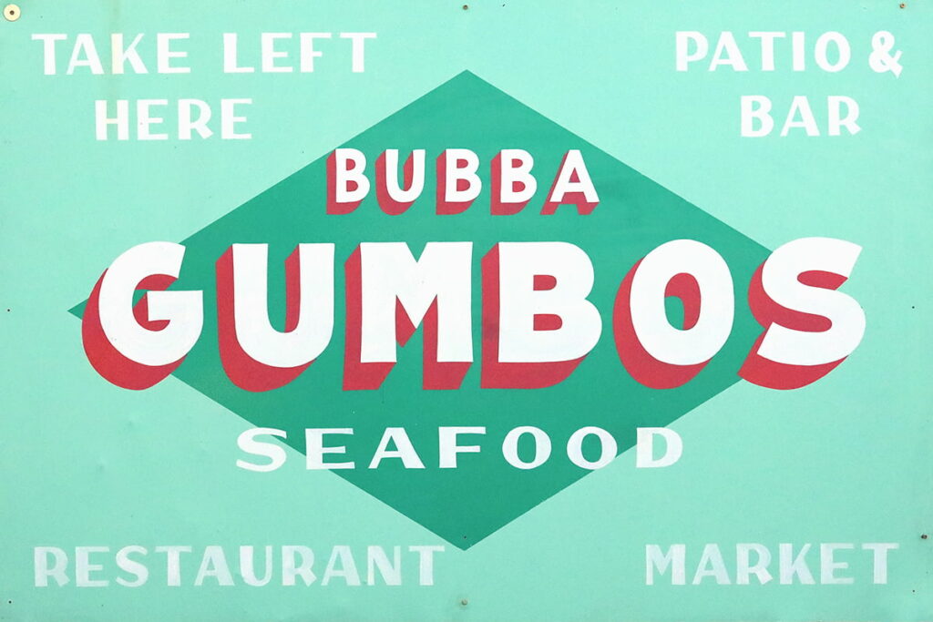 Colorful seafoam green sign with white and red lettering for Bubba Gumbos Seafood on Tybee Island, Georgia