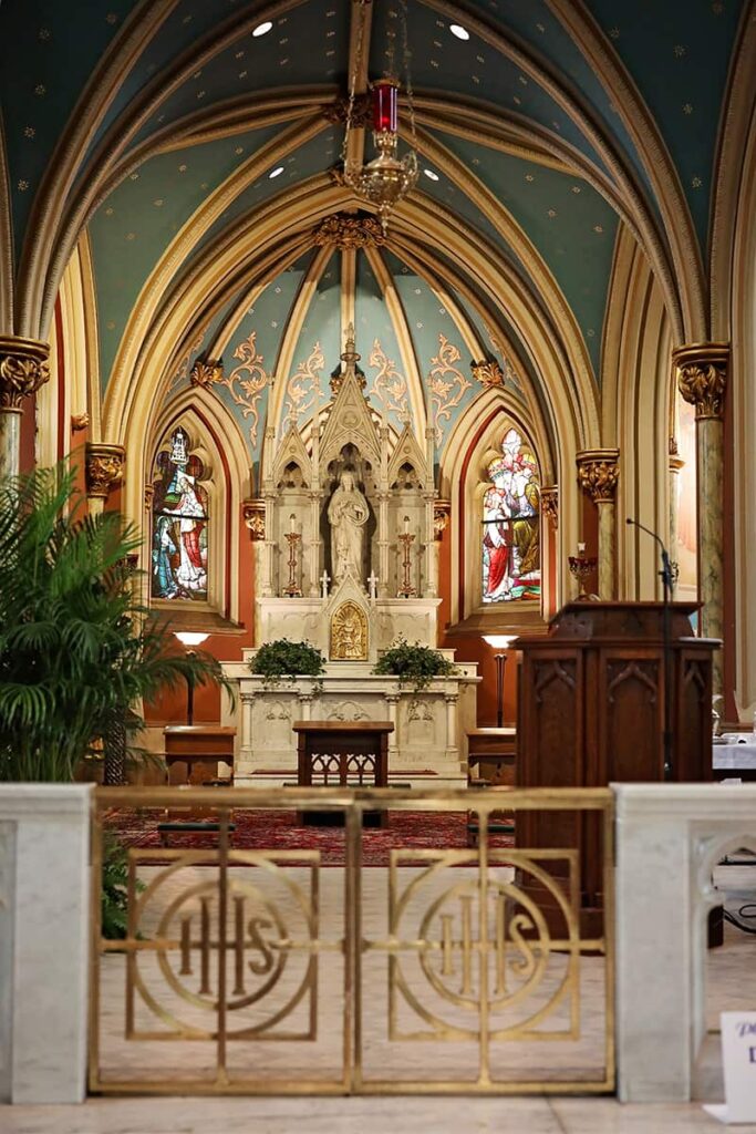 The Blessed Sacrament Altar at the Cathedral Basilica of Saint John the Baptist in Savannah, Georgia. A red candle hangs from a ceiling that is painted blue with gold star emblems