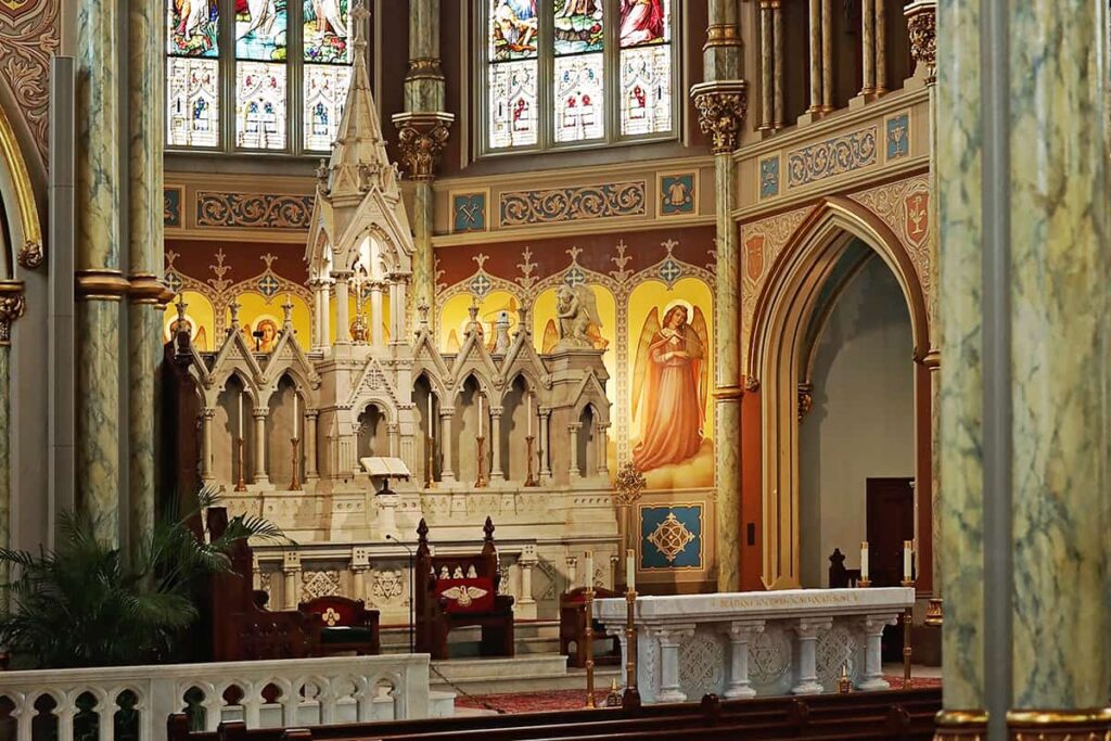 The massive original altar for the Cathedral Basilica of St. John the baptists serves as a backdrop with a smaller, less intricate altar in the foreground